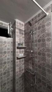 ein Badezimmer mit Dusche und gefliesten Wänden in der Unterkunft The Waves Studio in Patras