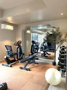 a gym with tread machines and a mirror at The 3sis Hotel in Chiang Mai