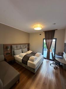 a bedroom with a bed and a desk and a computer at Intergroup Business & Design Hotel Ingolstadt in Kösching +110 photos