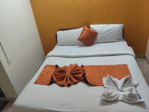 two beds with towels and bows on them at R K Residency Formerly Gamas in Trivandrum +8 photos