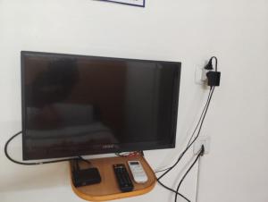 a flat screen television with a remote control on a wall at R K Residency Formerly Gamas in Trivandrum