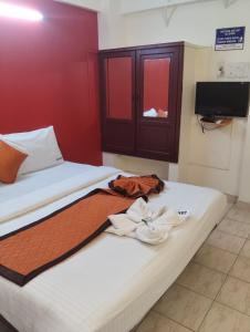 a bedroom with a bed with two towels on it at R K Residency Formerly Gamas in Trivandrum