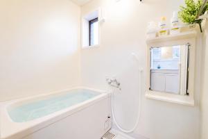 a white bathroom with a tub and a sink at Quiet Myoden-Disney & Tokyo Sightseeing Base in Ichikawa