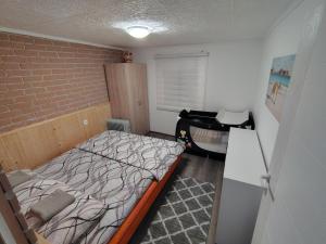 a small bedroom with a bed and a desk at Vikendica sa bazenom"Mila"Banja Topilo in Banja Topilo +34 photos