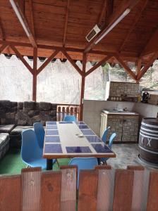 a table and chairs in a kitchen with a couch at Casa Puiu in Slănic-Moldova