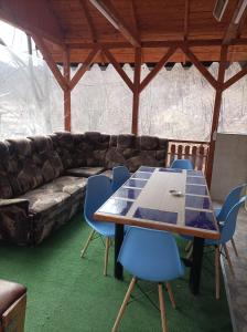 a table and chairs in a room with a couch at Casa Puiu in Slănic-Moldova +9 photos
