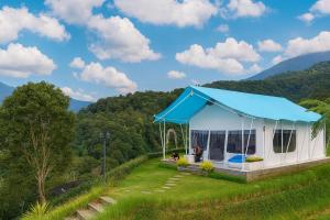 a white tent with a blue roof on a hill at Casa de Monique Glamping Resort in Bogor