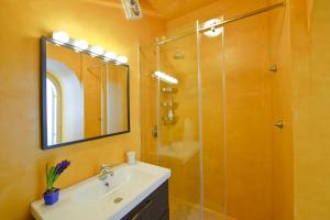 Un baño con lavabo y ducha con espejo. en Casale Fralisa, en Praiano 45 fotos más