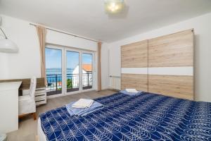 a bedroom with a large bed and a large window at Apartment Tus A1 in Crikvenica