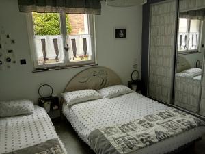 a bedroom with two beds and two windows at Au petit bonheur chez l'habitant in Ferques