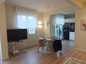 a living room with a table with chairs and a television at Luminoso Bilbao in Bilbao +16 photos