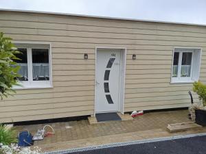 a house with a white door and two windows at Au petit bonheur chez l'habitant in Ferques