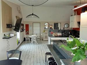 a kitchen and living room with a table and chairs at Au petit bonheur chez l'habitant in Ferques