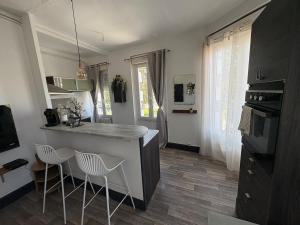 a kitchen with a counter and two stools at Le Balcon in Montargis