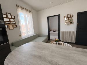 a living room with a table and a mirror at Le Balcon in Montargis