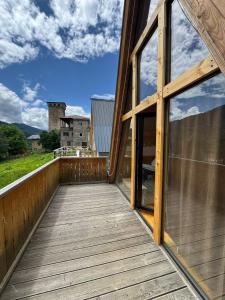 a wooden balcony with a view of a building at Hochaladah2 in Mestia