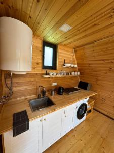 a kitchen with wooden walls and a sink and a window at Hochaladah2 in Mestia