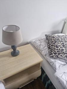 a bed with a table with a lamp on it at Cyprysowa 7 in Kiełczów