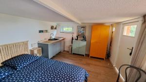 a small bedroom with a bed and a kitchen at L'Alizé du Levant in Île du Levant +39 photos