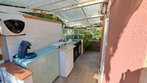 an outdoor kitchen with a sink and a greenhouse at L'Alizé du Levant in Île du Levant
