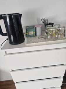 a white drawer with a black pitcher on top of it at Cyprysowa 7 in Kiełczów