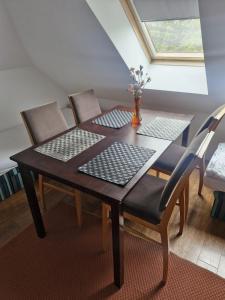a dining room table with two chairs and a window at Cyprysowa 7 in Kiełczów