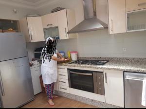 a woman is standing in a kitchen at Villa comfort in Bouznika