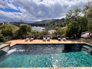 a swimming pool with two lounge chairs and a swimming pool at Ses Terrasses in Cadaqués
