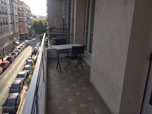 balkon ze stołem i samochodami przy ulicy miejskiej w obiekcie Le Palais Martine w Nicei