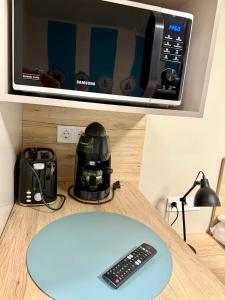 a microwave sitting on a counter with a remote control at Nautica Stúdió by HelloBalatonlelle in Balatonlelle