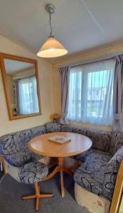 a living room with a table and a couch at MOLLIES DEN 2 8 Berth 3 Bedrooms The Grange Holiday Park INGOLDMELLS in Ingoldmells