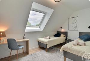a bedroom with two beds and a desk and a window at Gîte La Parenthèse in Troguéry
