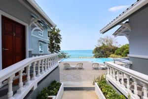 a house with a balcony with a view of the ocean at Sichon Goodwill in Sichon