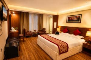 a hotel room with a large bed and a table at Woodland Heritage Hotel in Kathmandu