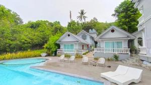 a home with a swimming pool and a house at Sichon Goodwill in Sichon