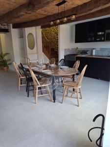 a dining room with a wooden table and chairs at la clé de la rance in Plouër-sur-Rance +15 photos