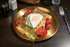 a plate of food with an egg and vegetables on a table at SFERA Boutique Rooms in Iaşi