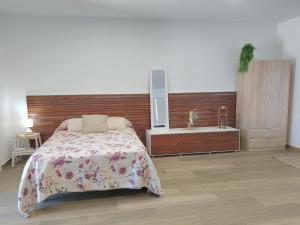 a bedroom with a bed and a wooden headboard at Alojamiento de Jorge in Herencia