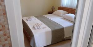 a bedroom with a bed with two towels on it at Sofia Comfort Apartment in Nivicë
