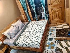 a small bedroom with a bed and a door at The Morchella House Tirthan Valley in Gushaini +5 photos