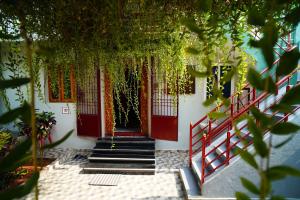 a red door on a white building with stairs at Sri Sakthi Residence in Tiruvannāmalai