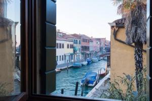 a view from a window of a canal with boats at Central Murano House in Murano