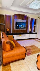 a living room with a couch and a flat screen tv at Godly Homes in Ruiru