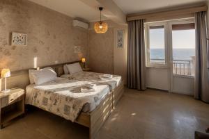a bedroom with a bed with a view of the ocean at Marea Blue Seaview Apartments of Santa Barbara in Marathias