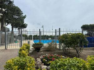 a garden with flowers in front of a fence at Residence Molo in Lido delle Nazioni