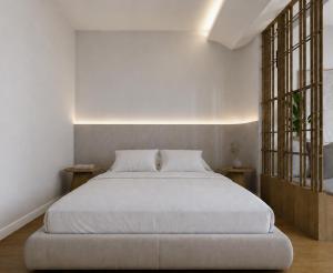 a bedroom with a white bed and two tables at Harmony Hotel Nafplio in Nafplio