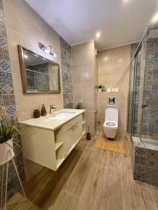 a bathroom with a sink and a toilet and a shower at Sunny Gym Studio Apartment in Burgas