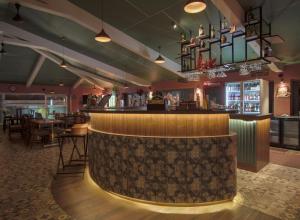 a bar in a restaurant with tables and chairs at New Vyankatesh in Mahabaleshwar