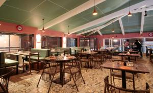 a restaurant with tables and chairs and people in the background at New Vyankatesh in Mahabaleshwar +68 photos