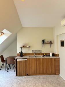 an attic kitchen with a sink and a table at Sunny Gym Studio Apartment in Burgas